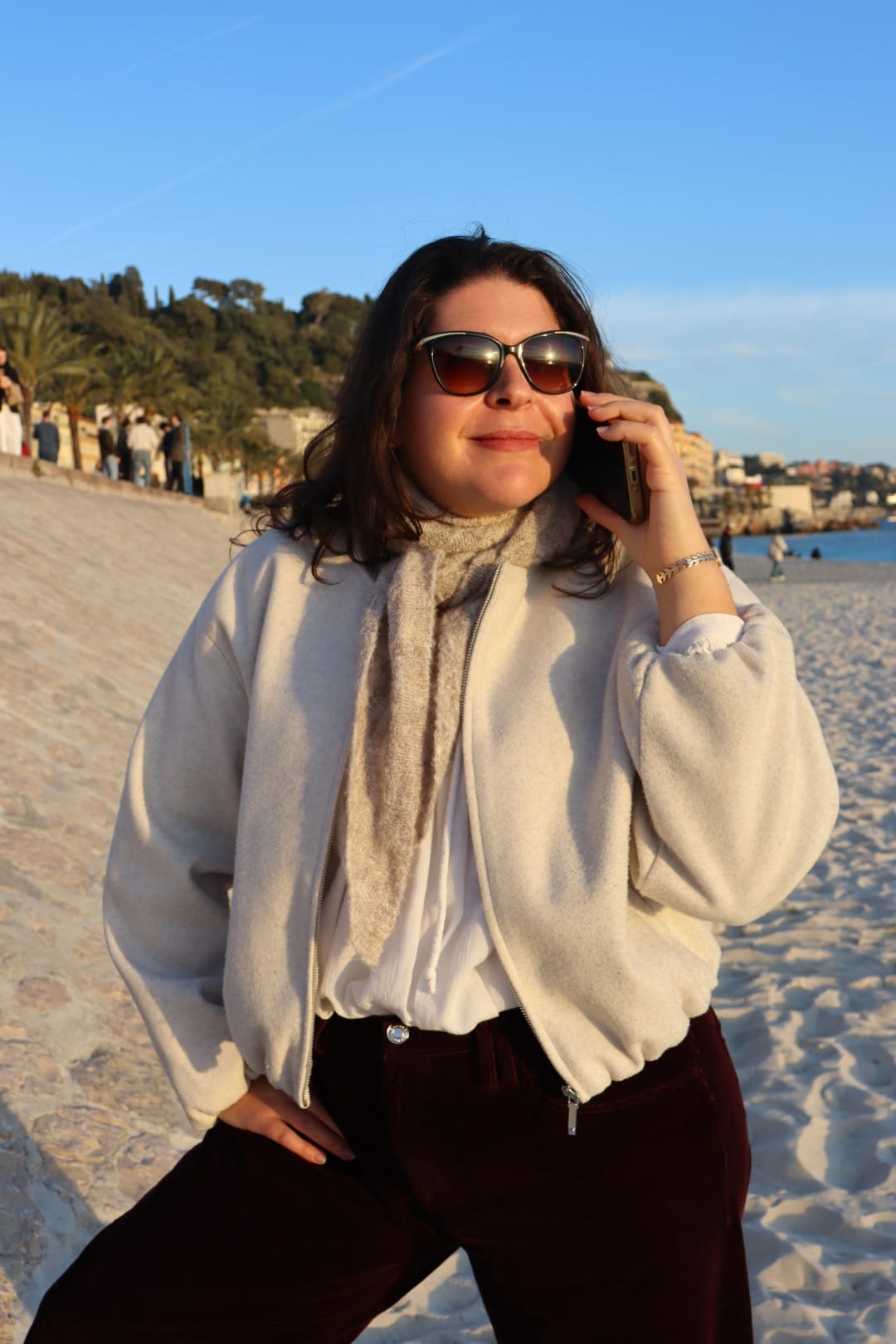 Nadia en appel avec une cliente en bord de mer